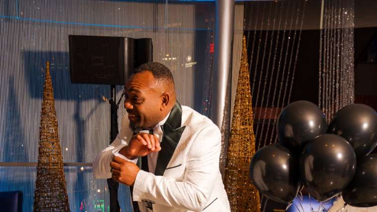 Guest in a white tuxedo jacket among balloons on concert night, Las Vegas live event photography