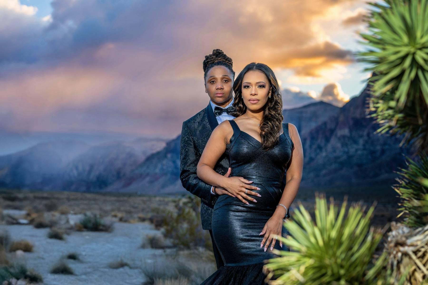Couple in navy formalwear beneath red sandstone at Red Rock Canyon, Las Vegas engagement photography