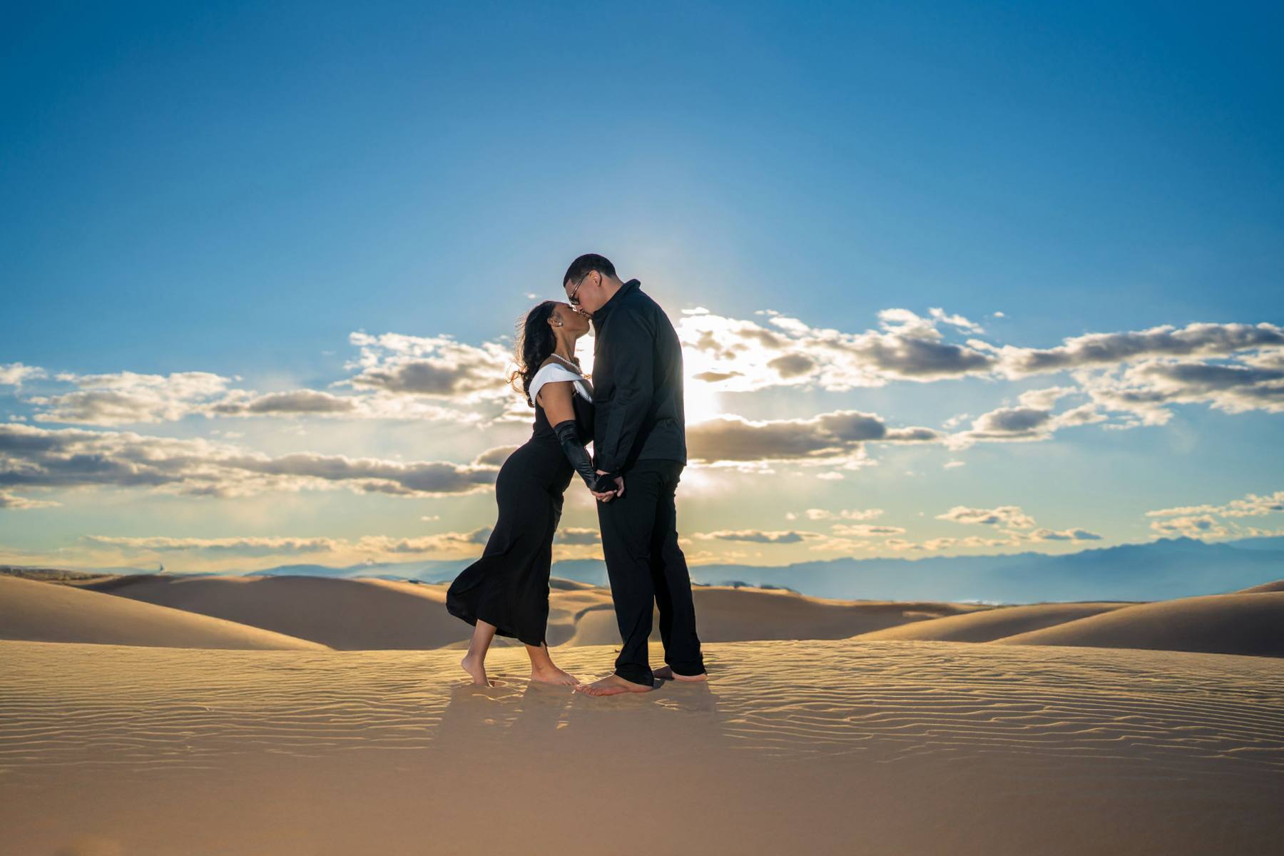 Couple embracing on the sand dunes at sunset north of Las Vegas, desert engagement photography