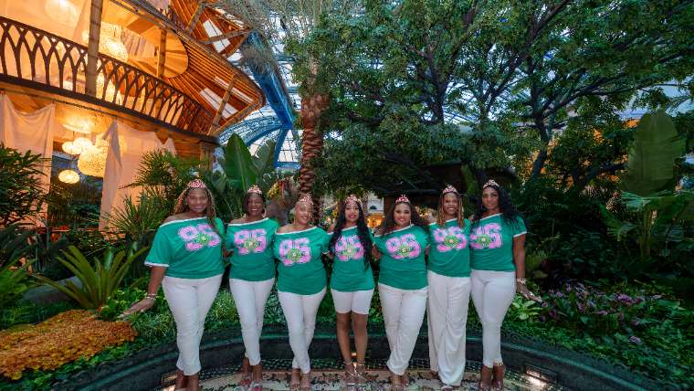 Chapter members in matching letters posed in a garden courtyard, Las Vegas sorority photoshoot