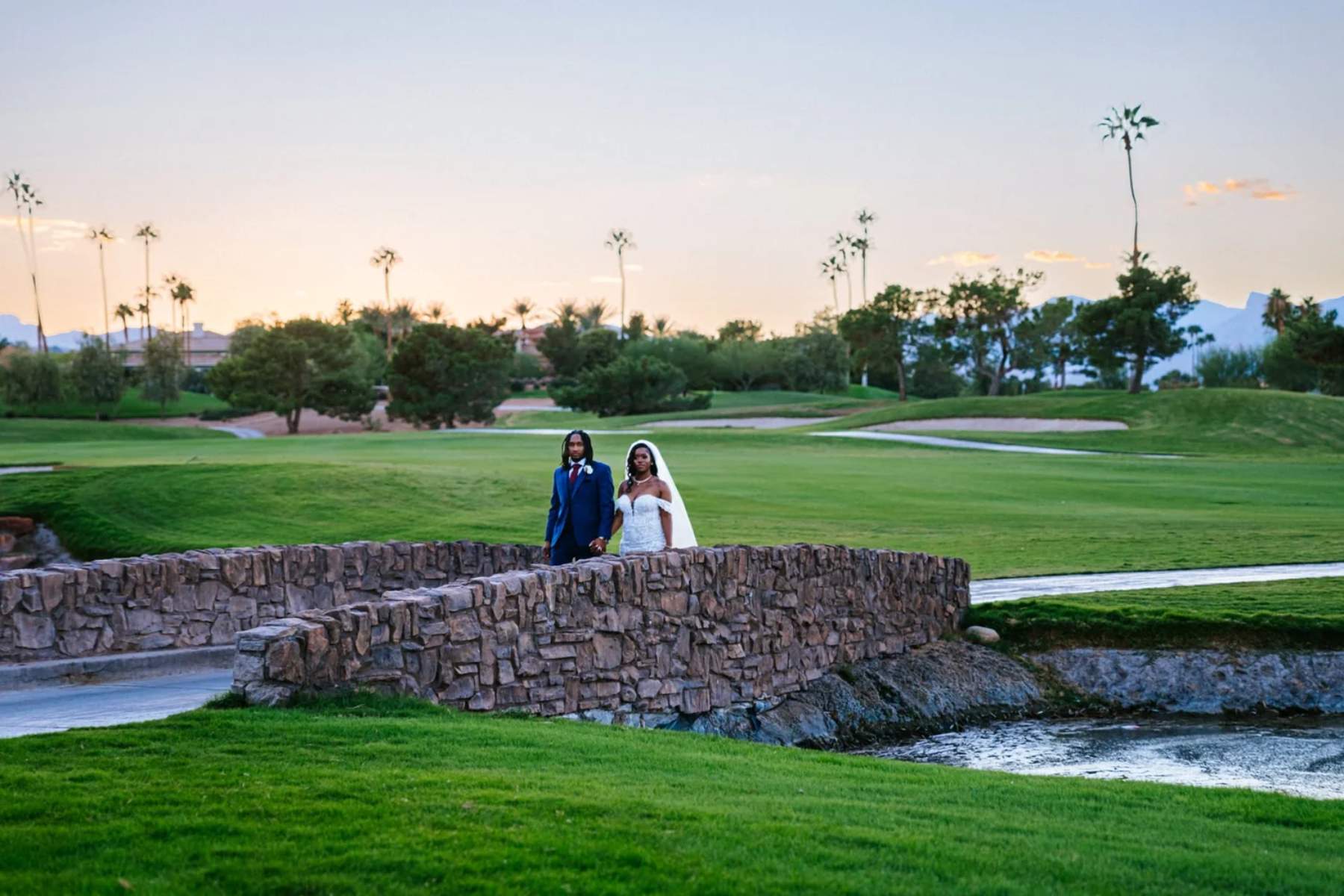 Bride and groom hand in hand on a golf course bridge at sunset, Las Vegas wedding photography